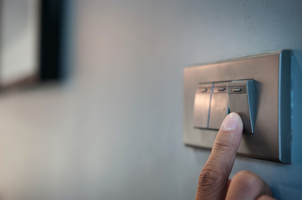 Tenant flipping a light switch in their new apartment